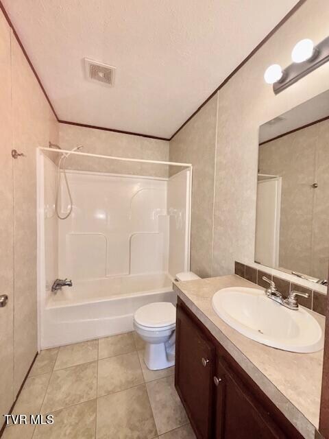 full bathroom featuring vanity,  shower combination, tile patterned floors, toilet, and a textured ceiling