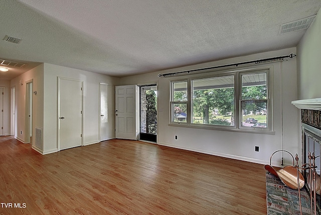 unfurnished living room with hardwood / wood-style floors and a textured ceiling