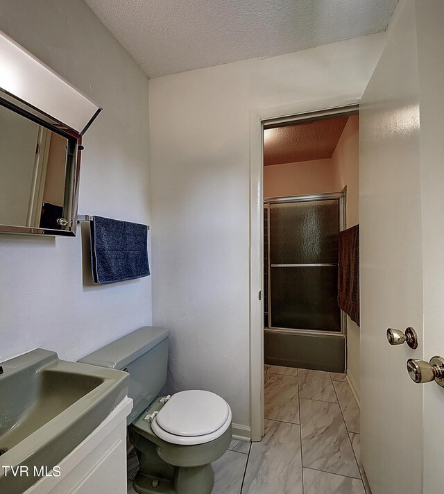 bathroom with toilet, sink, and a textured ceiling