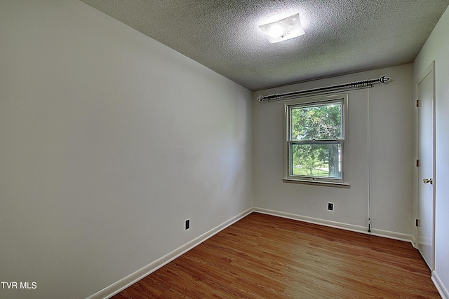 unfurnished room with a textured ceiling and light wood-type flooring