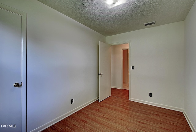 empty room featuring light hardwood / wood-style floors and a textured ceiling