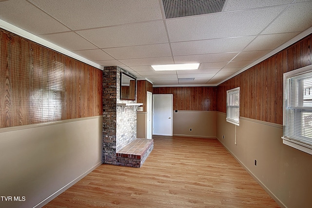 kitchen featuring a paneled ceiling, wood walls, and light hardwood / wood-style flooring