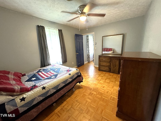 bedroom with ceiling fan, a textured ceiling, and light parquet floors