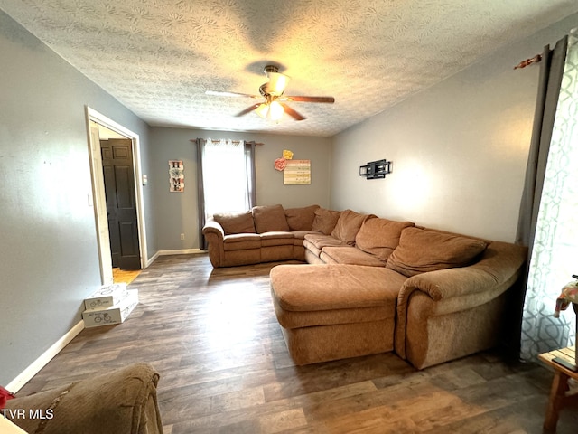 living room featuring a textured ceiling, dark hardwood / wood-style floors, and ceiling fan