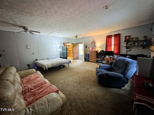 carpeted bedroom with ceiling fan, stainless steel refrigerator, and a textured ceiling