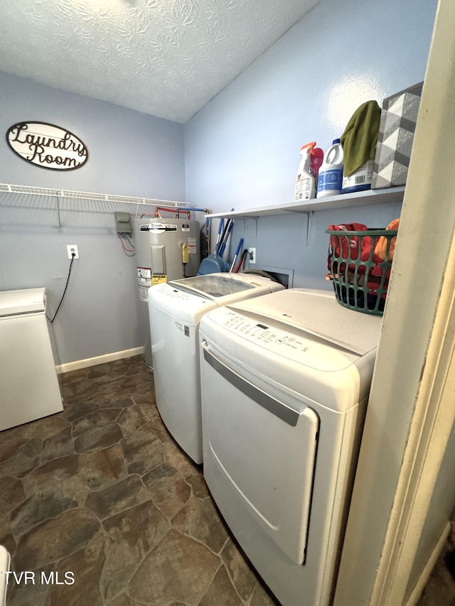 washroom featuring washer and clothes dryer, electric water heater, and a textured ceiling