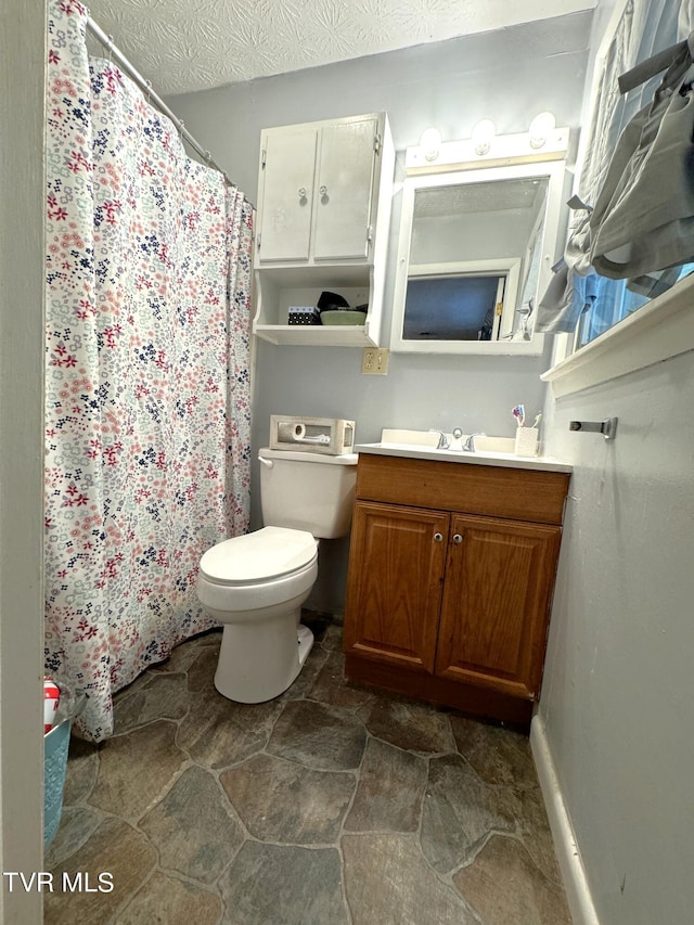 bathroom featuring vanity, a textured ceiling, and toilet