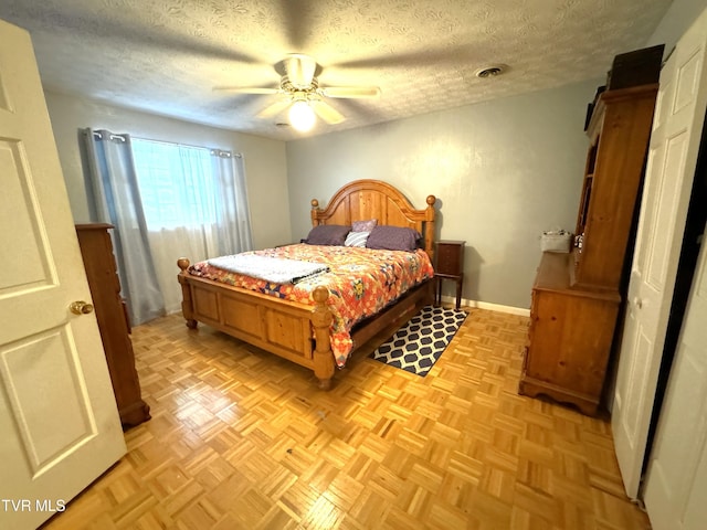 bedroom with ceiling fan, a textured ceiling, and light parquet floors