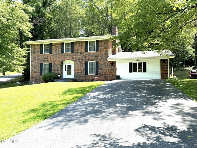 colonial house featuring a front lawn