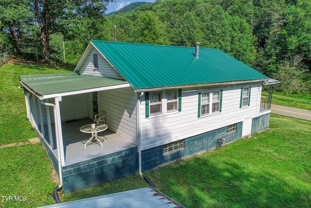 view of side of home featuring a patio and a yard