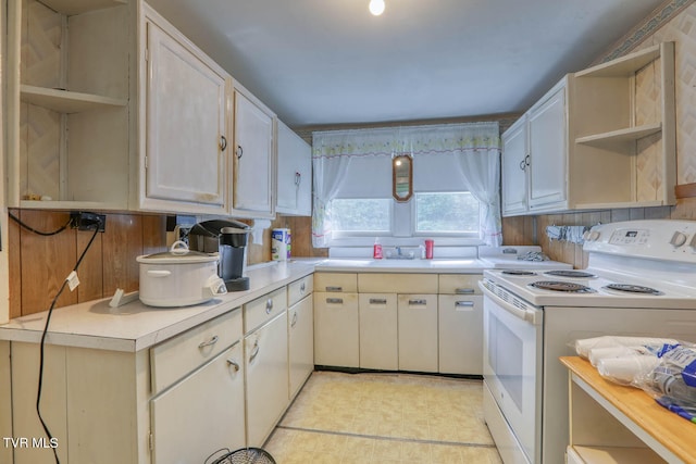 kitchen with white cabinets, light tile patterned flooring, tasteful backsplash, sink, and white range with electric stovetop