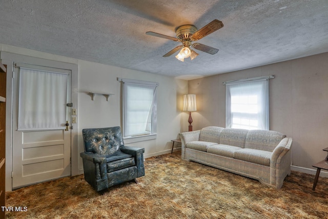 living room featuring ceiling fan, a textured ceiling, plenty of natural light, and carpet