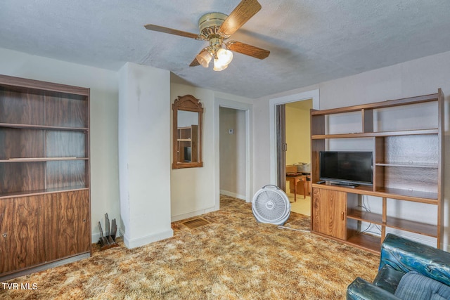 unfurnished living room with ceiling fan, a textured ceiling, and light colored carpet