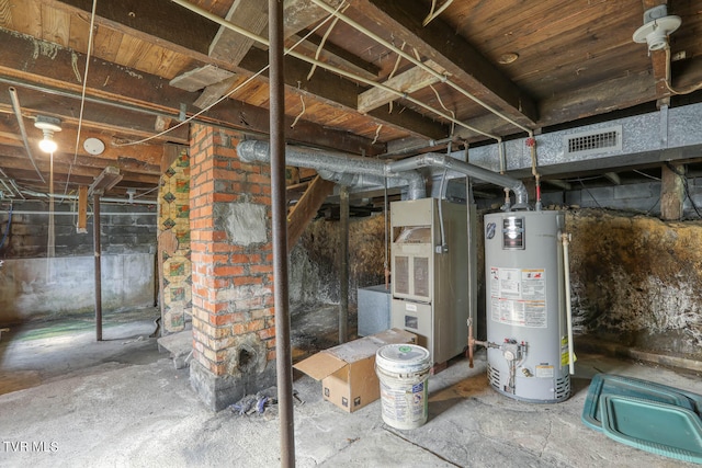 basement with gas water heater and brick wall