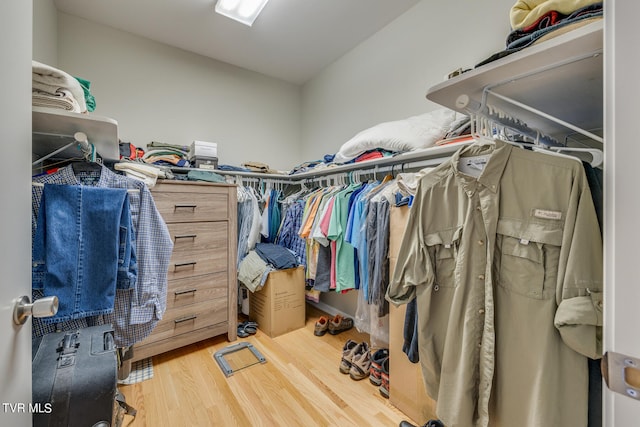 walk in closet with light hardwood / wood-style floors