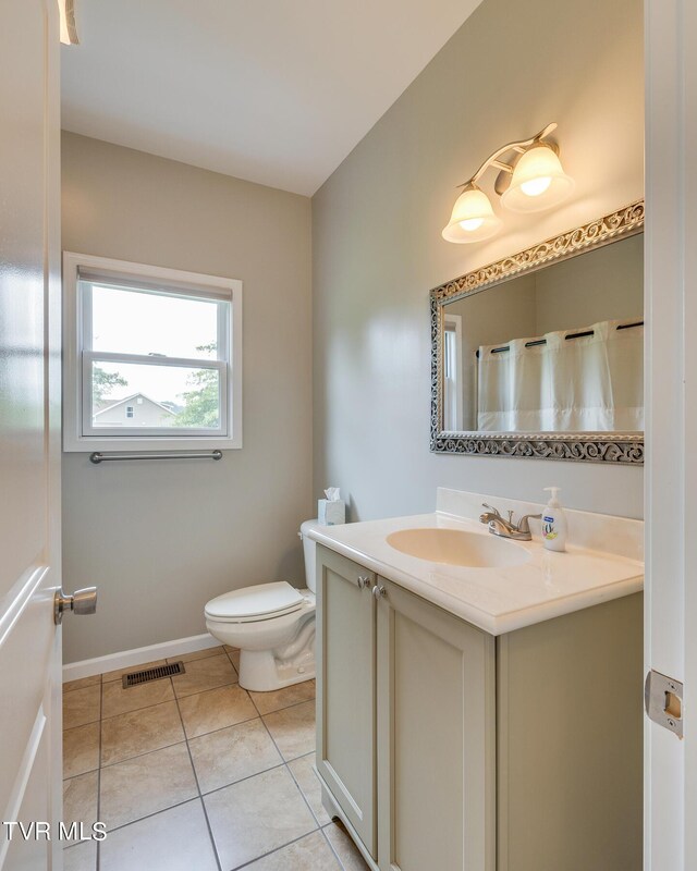 bathroom with vanity, tile patterned flooring, and toilet