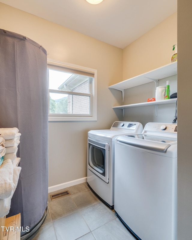 washroom featuring washer and dryer and light tile patterned floors