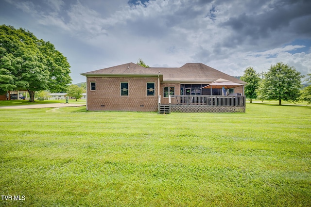 back of house featuring a wooden deck and a lawn