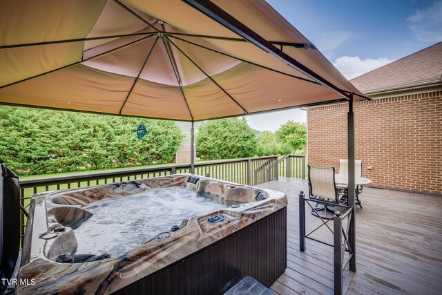 wooden terrace featuring a gazebo and a hot tub