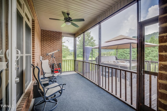 unfurnished sunroom with ceiling fan