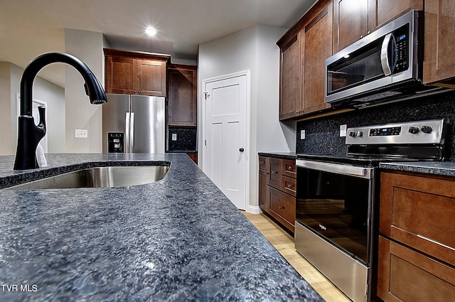 kitchen with appliances with stainless steel finishes, sink, and backsplash