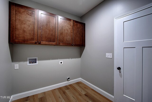 laundry room featuring light wood-type flooring, hookup for a washing machine, hookup for an electric dryer, and cabinets