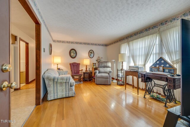 living room with light hardwood / wood-style floors and a textured ceiling