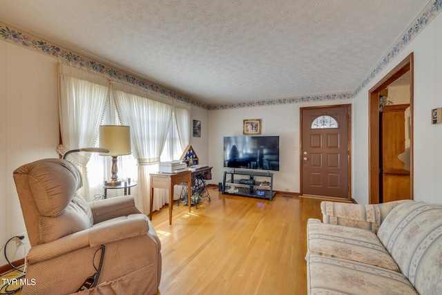 living room featuring light wood-type flooring and a textured ceiling