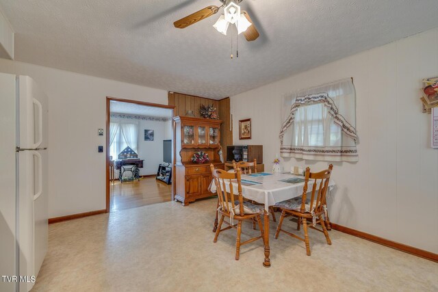 dining area featuring a textured ceiling, light wood-type flooring, and ceiling fan