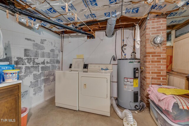 basement with water heater, brick wall, and independent washer and dryer