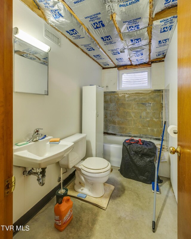 bathroom with sink, concrete flooring, and toilet