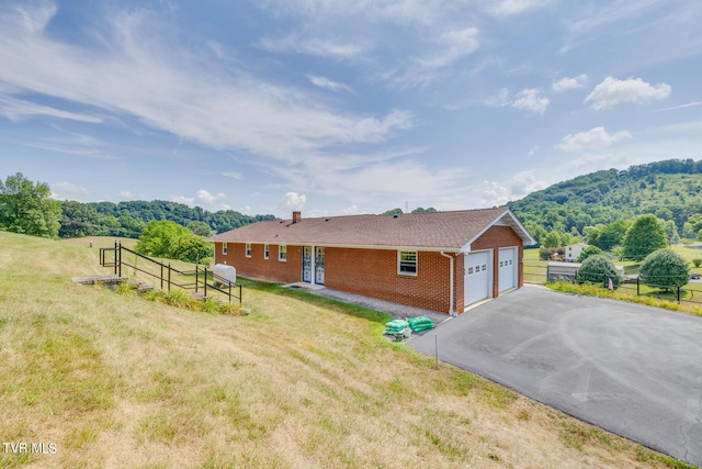 single story home with a garage and a front lawn