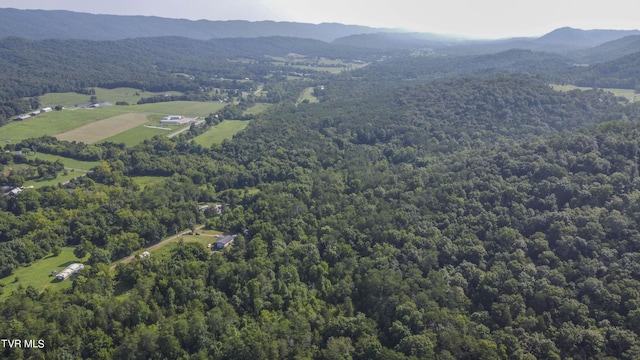 birds eye view of property with a wooded view and a mountain view