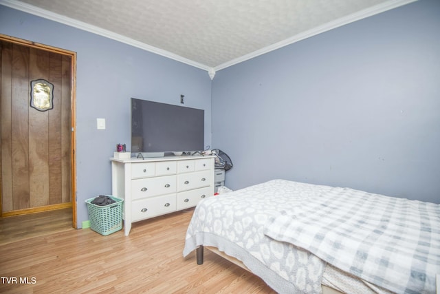 bedroom with light wood-type flooring, crown molding, and a textured ceiling