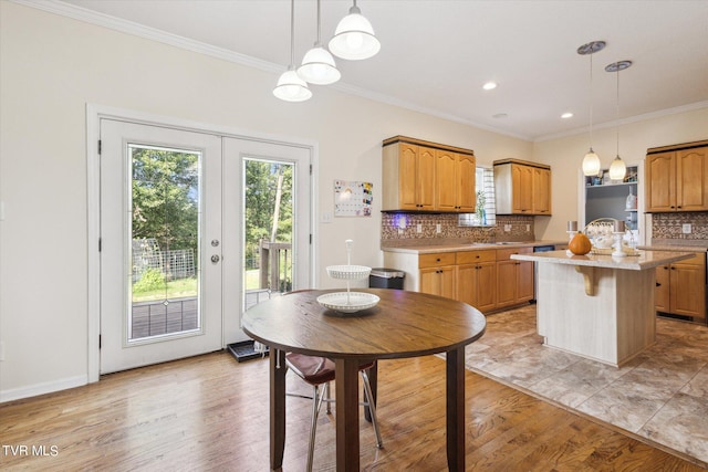 kitchen with tasteful backsplash, french doors, a kitchen island, and light wood-style flooring