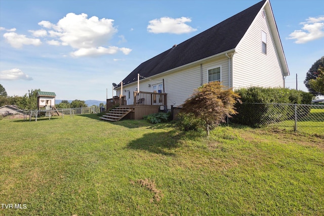 view of home's exterior featuring stairway, a yard, a deck, and fence