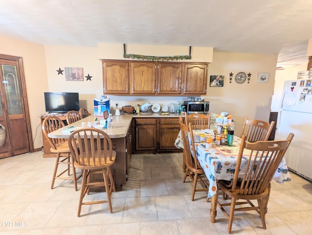 kitchen with white refrigerator and light tile patterned floors