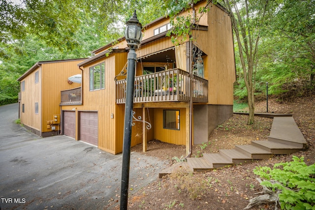 rear view of property featuring a garage and a deck