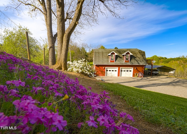 view of front of property with dirt driveway and a detached garage