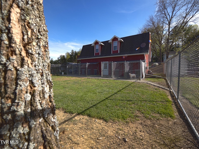 back of house featuring a yard, roof with shingles, and fence