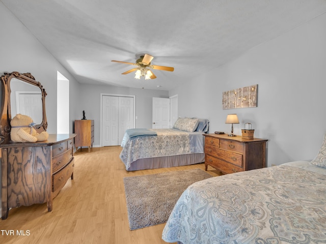 bedroom with a ceiling fan, a closet, and wood finished floors