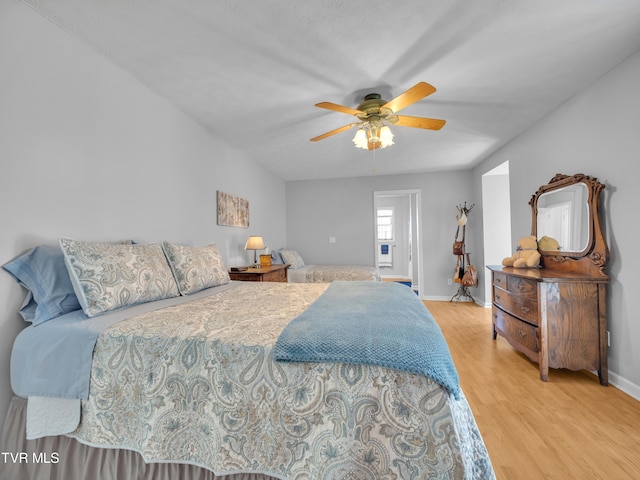 bedroom with a ceiling fan, baseboards, and wood finished floors