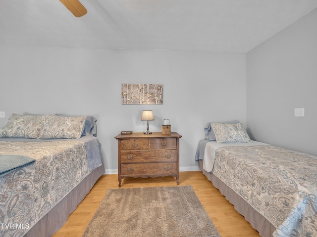 bedroom with ceiling fan, wood finished floors, and baseboards