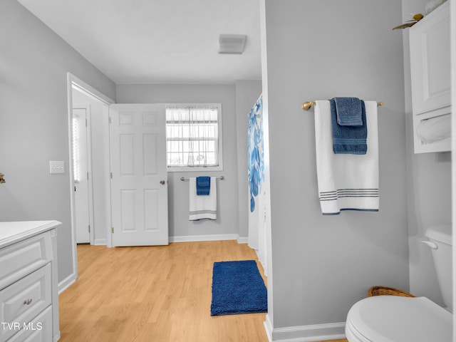 full bathroom featuring vanity, wood finished floors, toilet, and baseboards