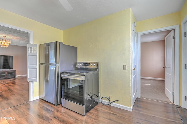 kitchen featuring hardwood / wood-style flooring, stainless steel appliances, and a notable chandelier