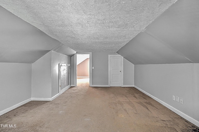 bonus room with vaulted ceiling, carpet floors, and a textured ceiling