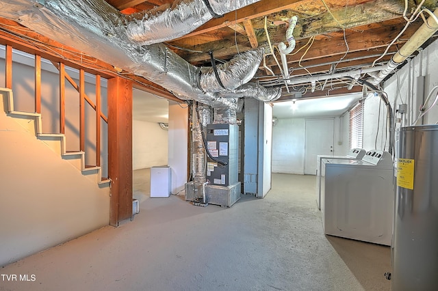 basement featuring heating unit, water heater, and washing machine and clothes dryer