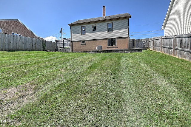 rear view of house with a yard and central air condition unit