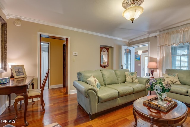 living room with ornamental molding, baseboards, and wood finished floors