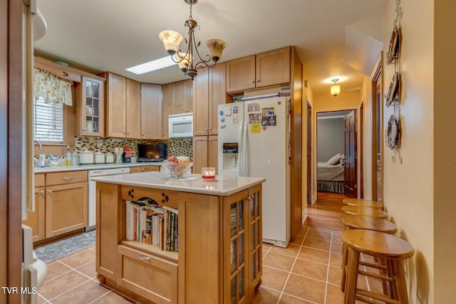 kitchen with white appliances, light countertops, backsplash, and light tile patterned floors